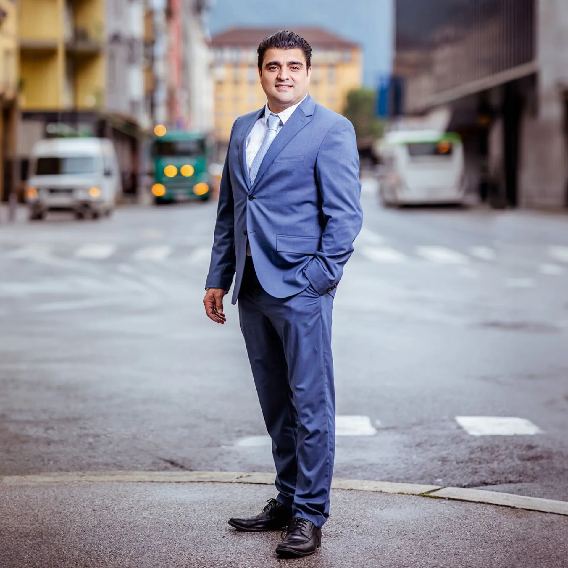 MMag. Yavuzhan Öztürk steht im Anzug auf einer Straße in Innsbruck
